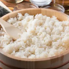 Gotowany ryż do sushi w drewnianej kadzi z drewnianą łopatką.